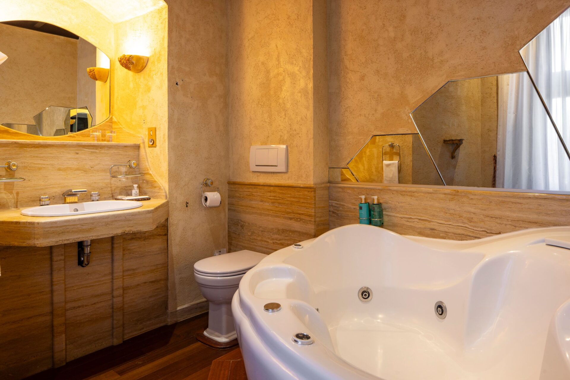 une salle de bain avec baignoire en angle accompagnée de produits d’accueil