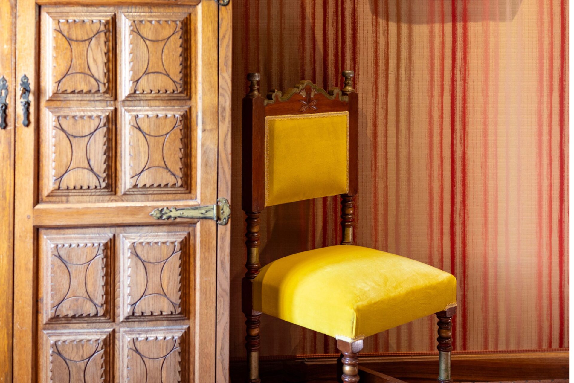 Chaise jaune et porte en bois dans la chambre Jacques Cœur