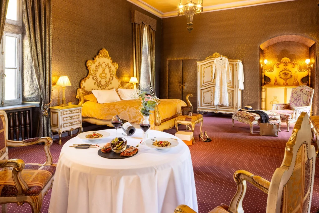 Table avec nourriture et vin, avec lit et décoration dans la chambre Aldin de Codignat