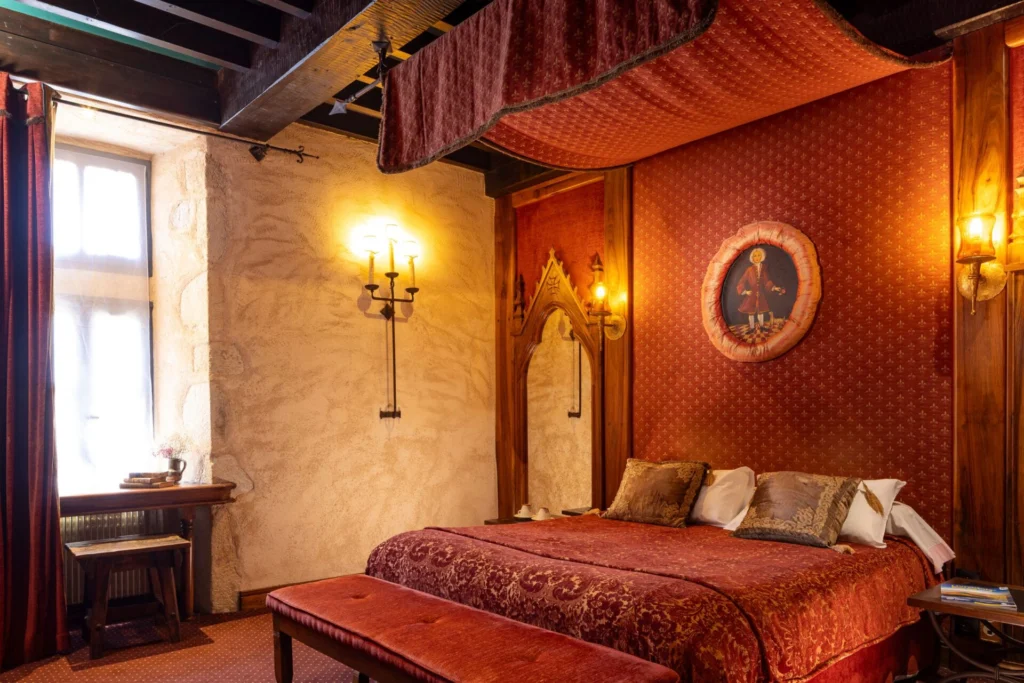Vue large de la chambre Suite Royale Bâtard d’Orléans, décorée de rouge somptueux.