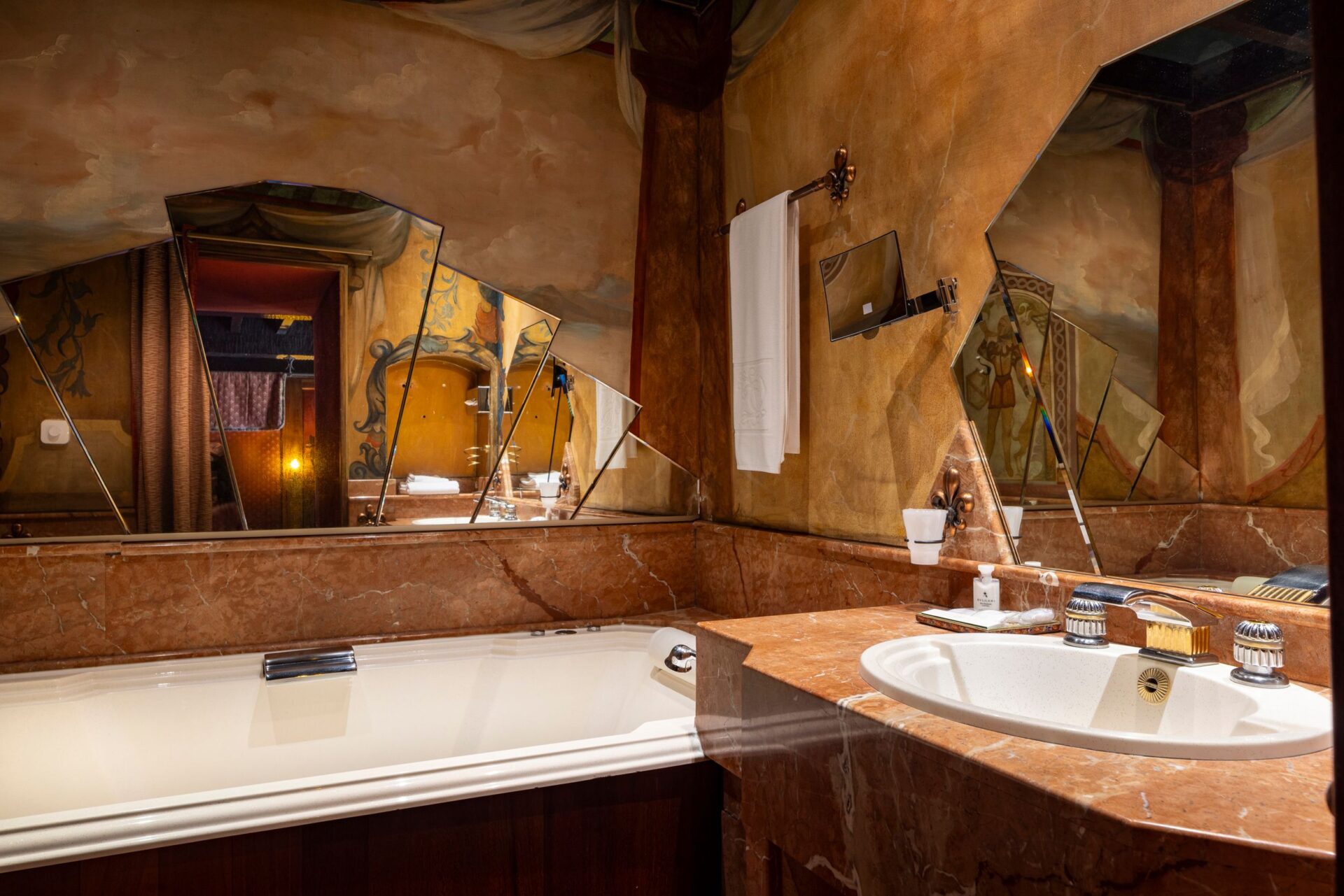Baignoire et lavabo dans la salle de bain de Bâtard d’Orléans, décorés avec marbre et miroir