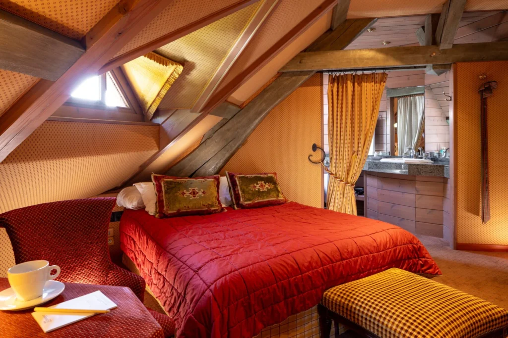 Chambre Deluxe Le Colombier, nichée sous les toits au troisième étage du château, avec charme mansardé et atmosphère feutrée