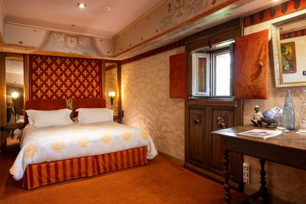 Lit, table et vue par la fenêtre dans la chambre Donjon