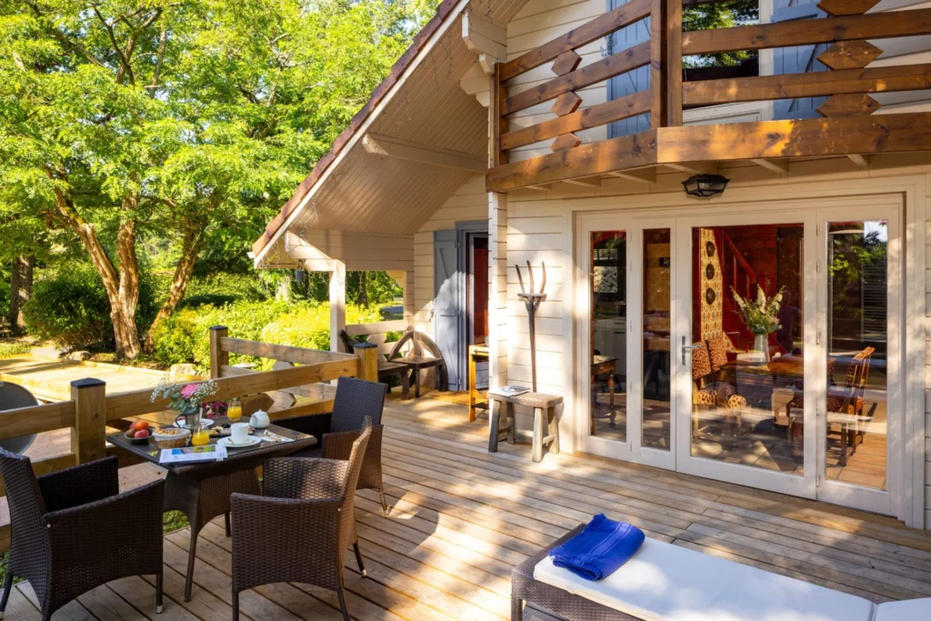 Façade du gîte Myrtille avec porte vitrée, décoration en bois et accès pour personnes à mobilité réduite sur le côté