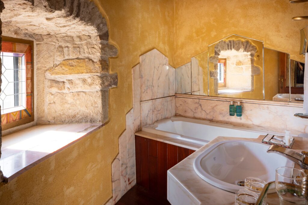 Baignoire et lavabo avec décoration en marbre dans la salle de bain de Lucrèce Borgia