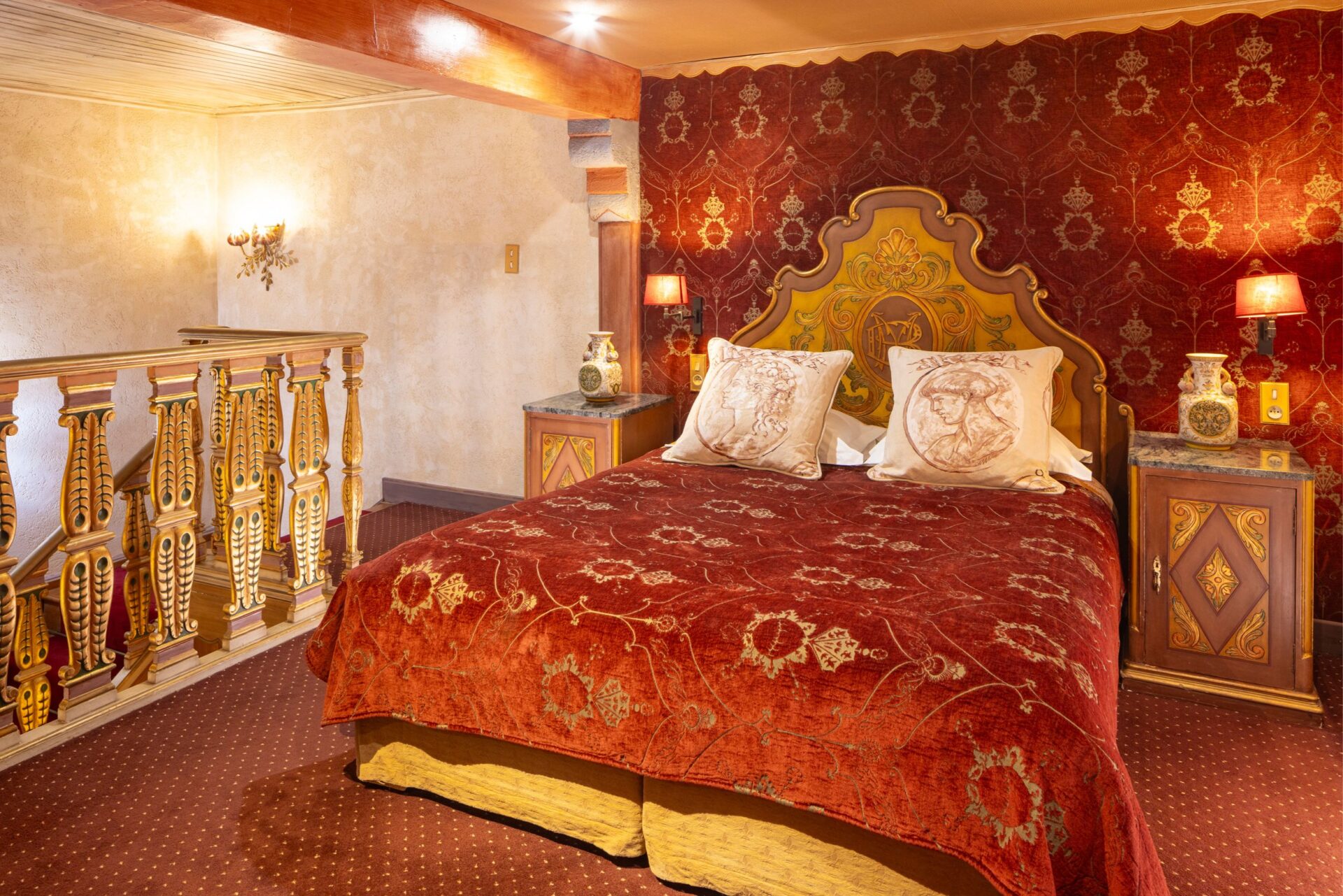 Lit avec décoration rouge et or dans la chambre Reine Victoria