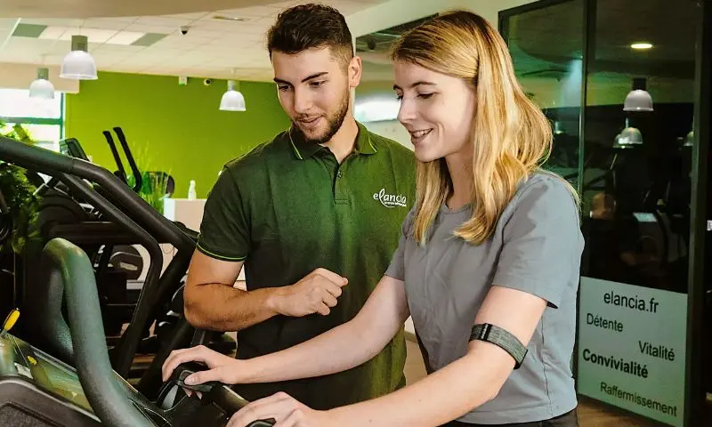 Personnel Elancia conseillant une personne sur les techniques d’exercice et l’utilisation des appareils de fitness